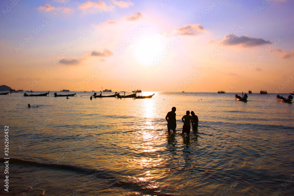  Tourist family are enjoy swimming on sea in evening time before sun set.silhouette group of people in relax time with seascape,cloud sky nature .