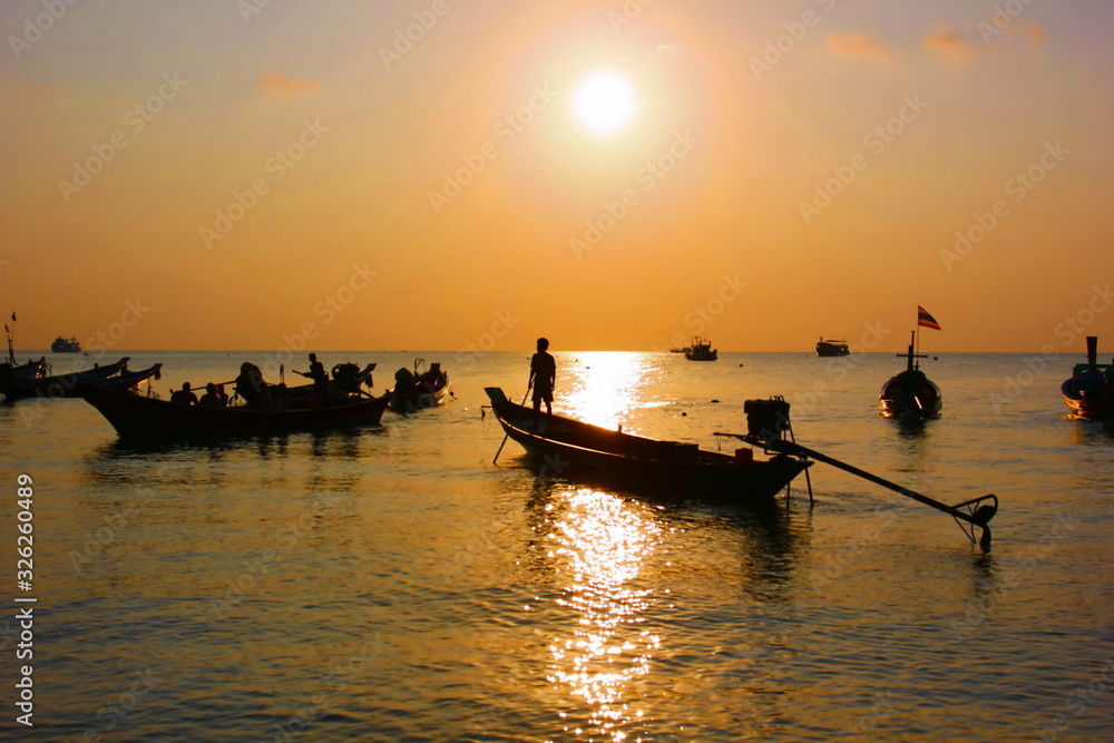 silhouette group of long tail boats parking on coast after service the tourist in evening time.