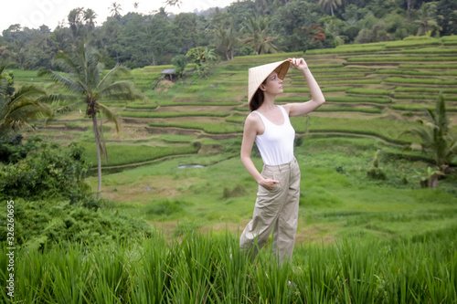 Woman wearing traditionl bamboo hat on the rice field terrace	 photo