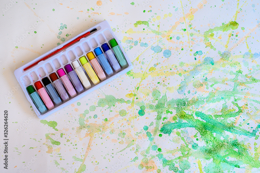 Φωτογραφία Color tube in a watercolor box on the white paper smear the color, Education and art object, top view