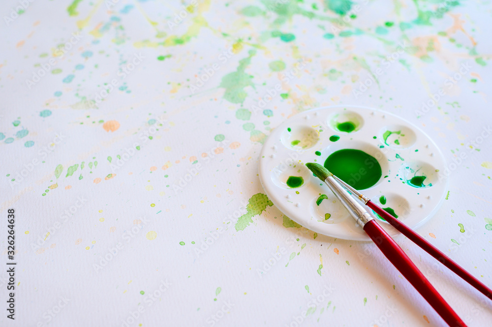 Φωτογραφία Paintbrush and watercolor paint, Palettes on the white paper smear the color, Education and art object