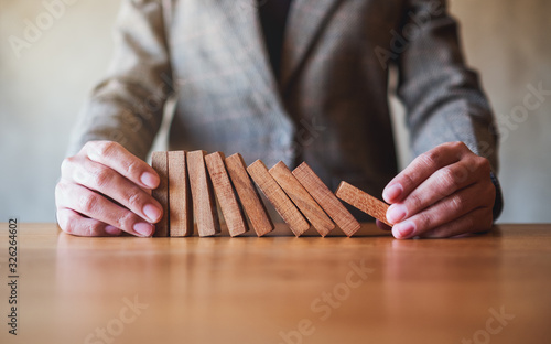Closeup image of a businessman try to holding wooden block while falling for business concept