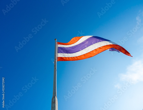 Flag of Thailand waving in the wind on old white wooden pole from bottom view.