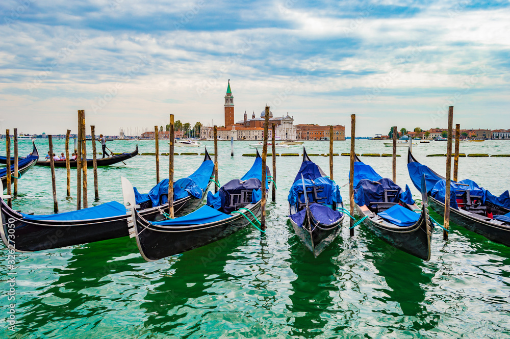 Venice, Italy - CIRCA 2013: Venice gondolas at a cloudy afternoon. San Giorgio Maggiore Church is visible on the background.