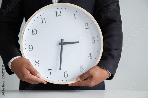 Businessman holding a clock ready to work Strategy and time management in the office, Concept: symbol manage at deadline professional for success, Time to take a summer vacation, manager hour job