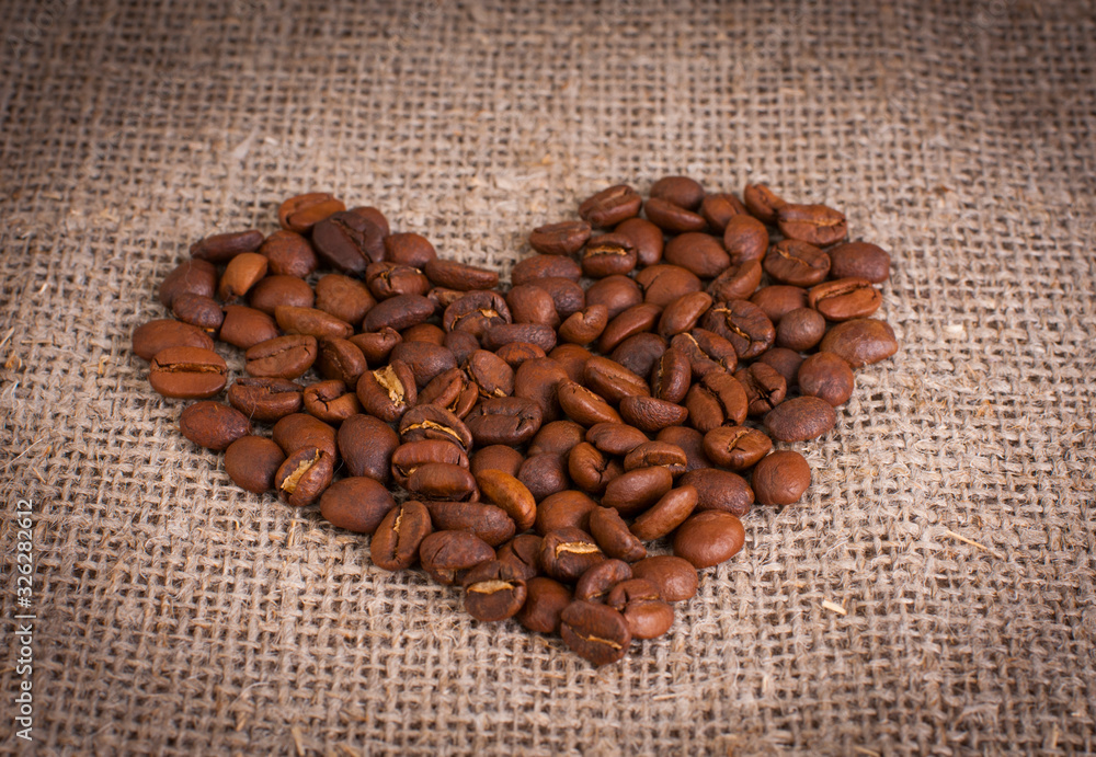 Φωτογραφία coffee beans in shape of heart on wooden background