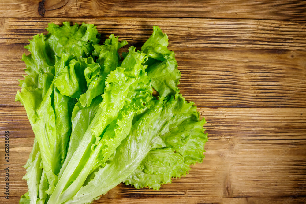 Fresh green lettuce leaves on wooden table. Top view Fresh green lettuce leaves on wooden table. Top view