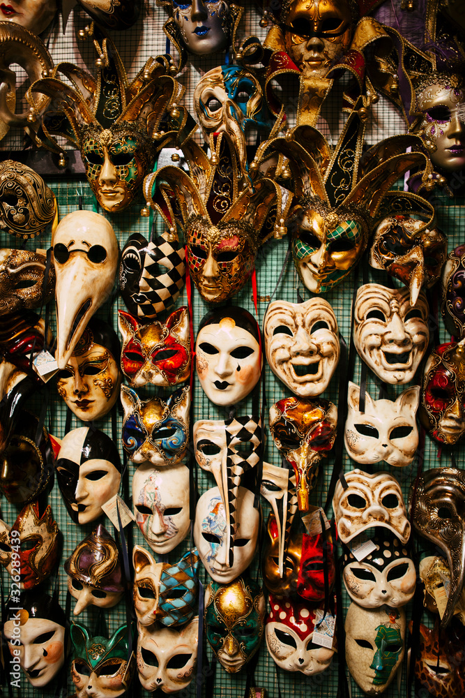 Close up view of colorful male and female carnival masks hand-painted by Italian craftsmen in a local store in the center of Venice, Veneto, Italy. Traditional European medieval culture