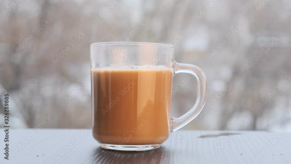 a cup of coffee on the windowsill of an open window, pour coffee into a cup and milk. a cup of coffee on the windowsill of an open window, pour coffee into a cup and milk.