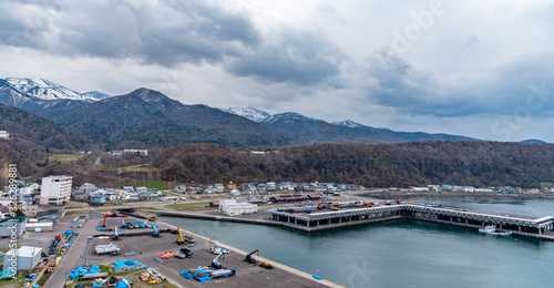 View of Utoro fishing port in springtime with Shiretoko mountain range at Utoronishi. Town Shari, Shiretoko Peninsula. Hokkaido, Japan