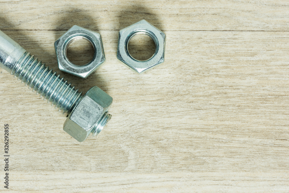 Metal screw and nut on floor.