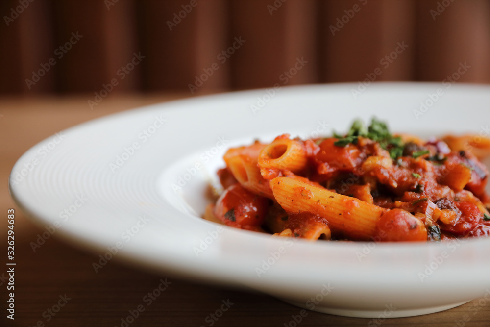 Penne arrabiata pasta tomato sauce with spices italian food on wood background Penne arrabiata pasta tomato sauce with spices italian food on wood background