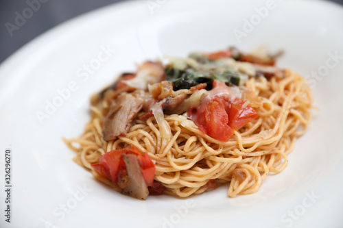 spaghetti Bolognese with minced beef and tomato sauce garnished with parmesan cheese and basil , Italian food