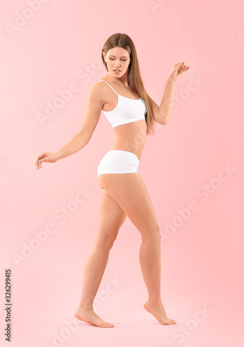 Beautiful young woman in underwear on color background © Pixel-Shot