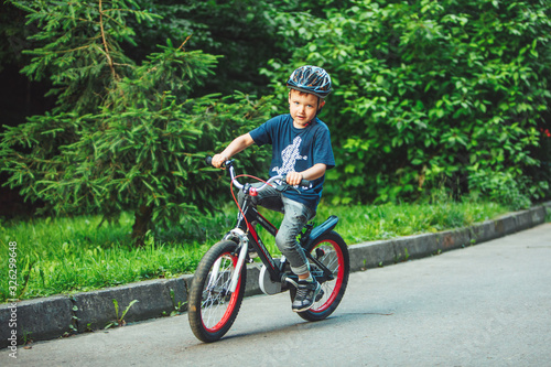 Lviv, Ukraine - June 23, 2019: little boy riding on bicycle in helmet