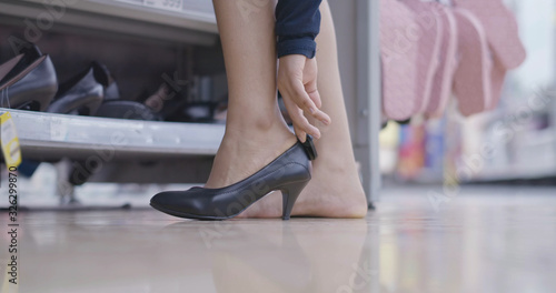 Close up shopping young woman chooses high-heel shoes in shopping mall store beautiful people lifestyle
