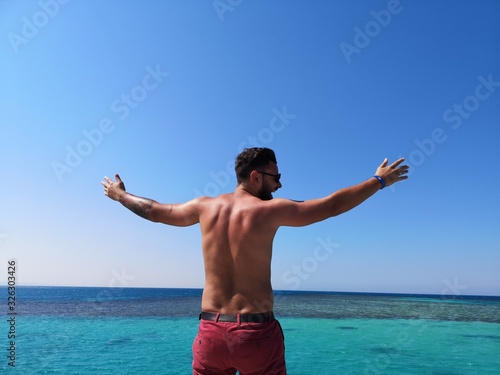  men's back against the backdrop of a water plexus of the sea, relax and high on the sea © Вікторія Хірна