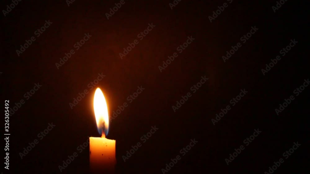 Close-up of a Candlelight Isolated on a Black Background, candlelight moves in the wind Close-up of a Candlelight Isolated on a Black Background, candlelight moves in the wind