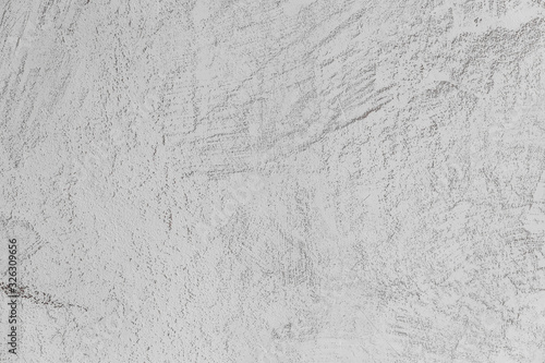 exture of concrete and plaster on the wall. Lines in the plaster. Texture of decorative plaster or stucco close up, abstract gray background.