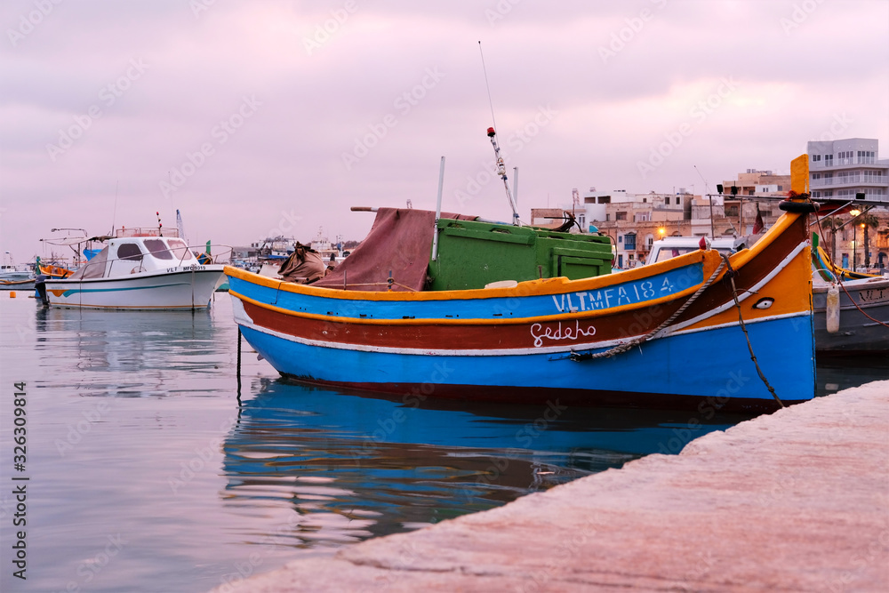 traditional fishing boats of Marsaxlokk, Malta at sunset