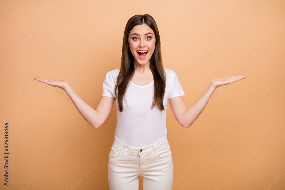 Portrait of astonished crazy girl promoter hold hand recommend suggest select adverts present promo impressed scream wow omg wear white pants trousers isolated over beige color background Portrait of astonished crazy girl promoter hold hand recommend suggest select adverts present promo impressed scream wow omg wear white pants trousers isolated over beige color background