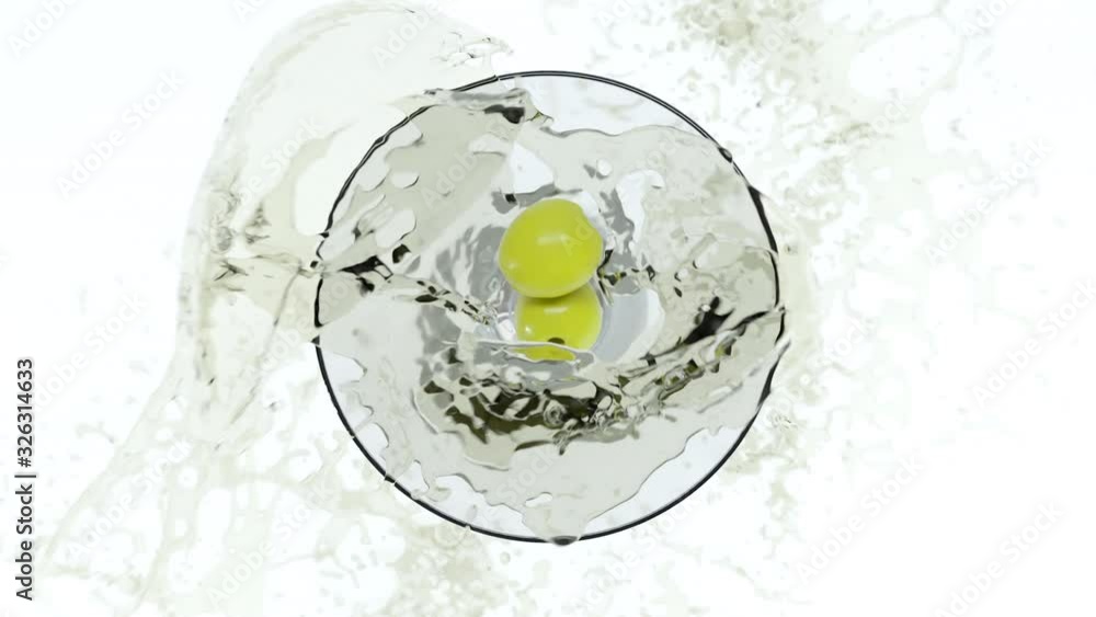 Two green olives falling in glass with martini inside in slow motion. Martini splash with olives inside. Alcohol glass with liquid pours out of glass. 3D render animation footage. Top view. Two green olives falling in glass with martini inside in slow motion. Martini splash with olives inside. Alcohol glass with liquid pours out of glass. 3D render animation footage. Top view.
