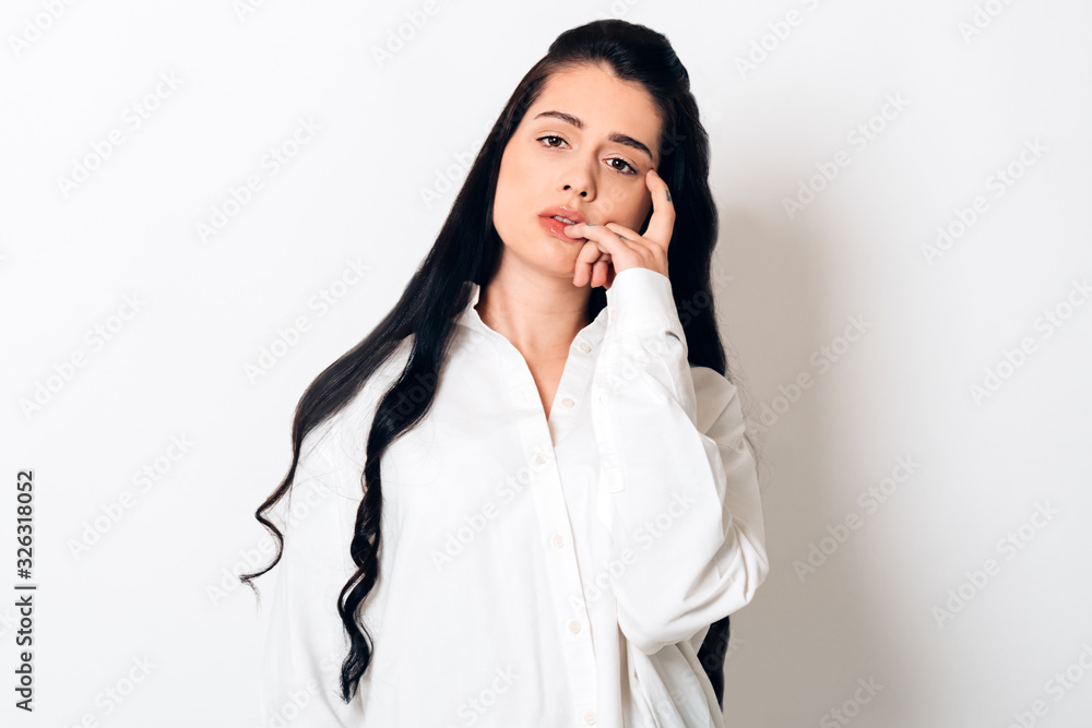 sensual young woman with long black hair looking at camera on white background sensual young woman with long black hair looking at camera on white background