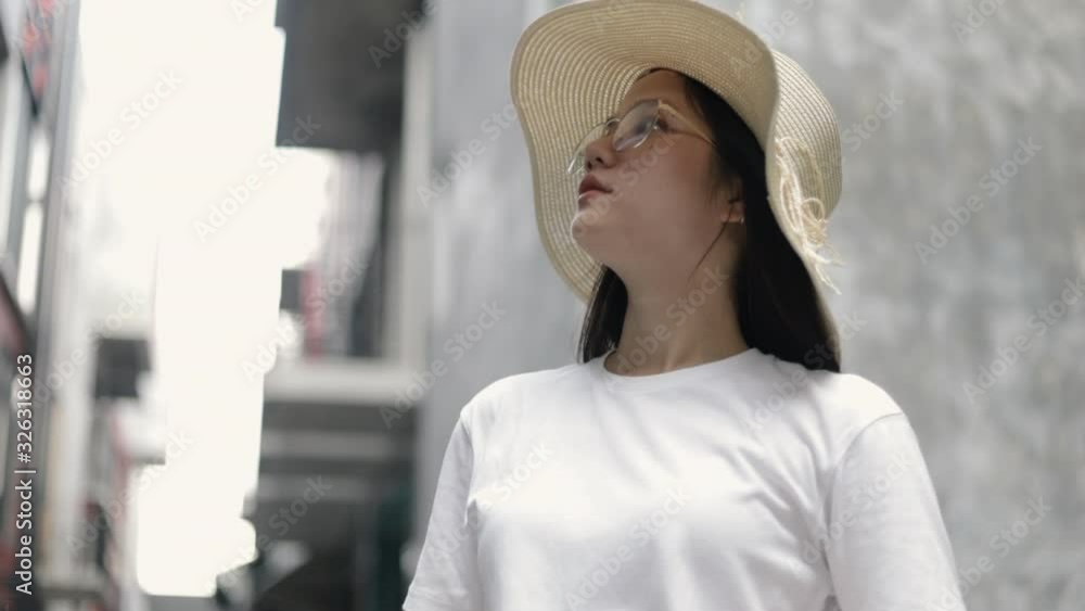 Attractive of portrait young asian woman wearing fedora hat and glasses looking around in the old town. Travel exploring concept, vacation summertime. Attractive of portrait young asian woman wearing fedora hat and glasses looking around in the old town. Travel exploring concept, vacation summertime.