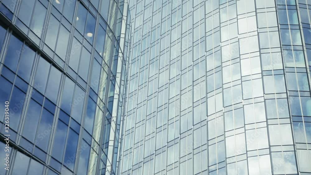 Time lapse of clouds reflecting onto the glass of a large office building. Reflection of clouds in a modern skyscraper. Time lapse of clouds reflecting onto the glass of a large office building. Reflection of clouds in a modern skyscraper.
