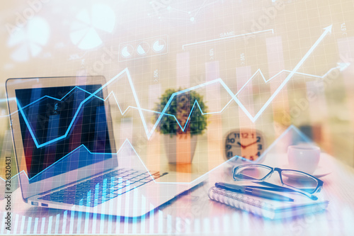 Stock market graph on background with desk and personal computer. Multi exposure. Concept of financial analysis.