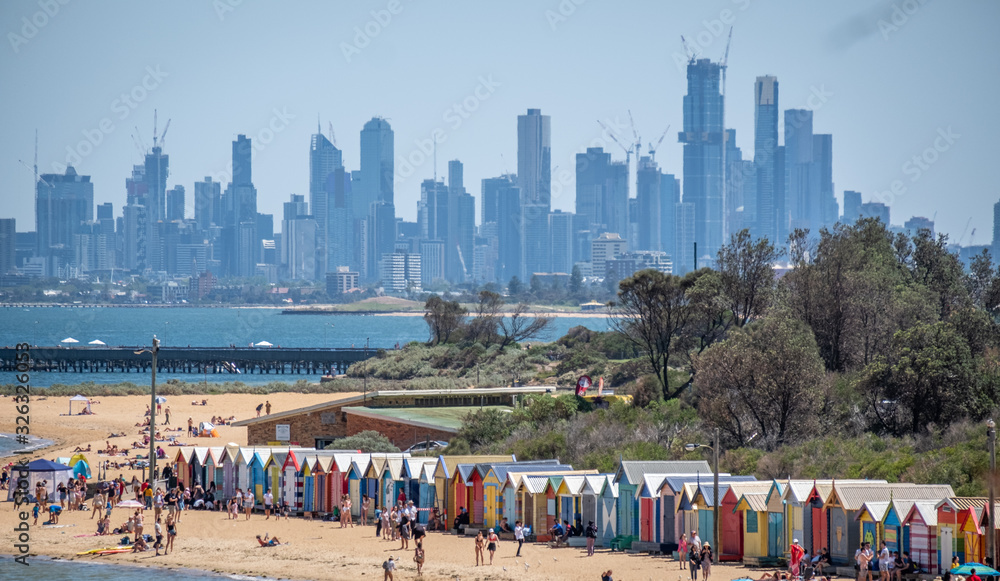 Obraz premium View from above of Brighton Beach huts in front of Melbourne Skyline