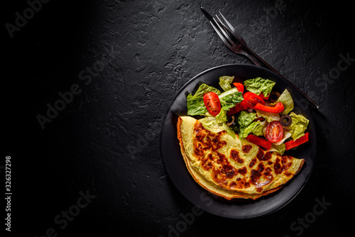 Εκτύπωση καμβά omelet with fresh mixed vegetables  salad on a black plate on Dark grey black sl
