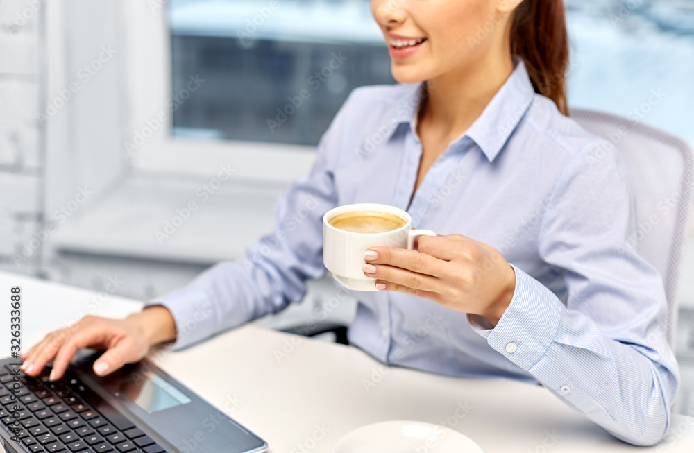 business, deadline and technology concept - close up of happy smiling businesswoman with coffee and laptop at office business, deadline and technology concept - close up of happy smiling businesswoman with coffee and laptop at office