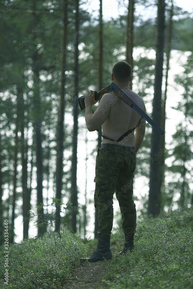 man goes hunting forest summer / landscape in the forest, huntsman with a hunting rifle hunts man goes hunting forest summer / landscape in the forest, huntsman with a hunting rifle hunts