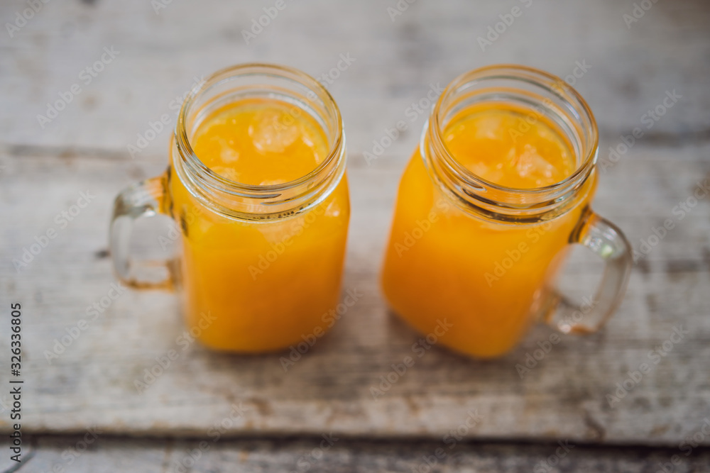 Orange juice in mason jar on wooden background Orange juice in mason jar on wooden background