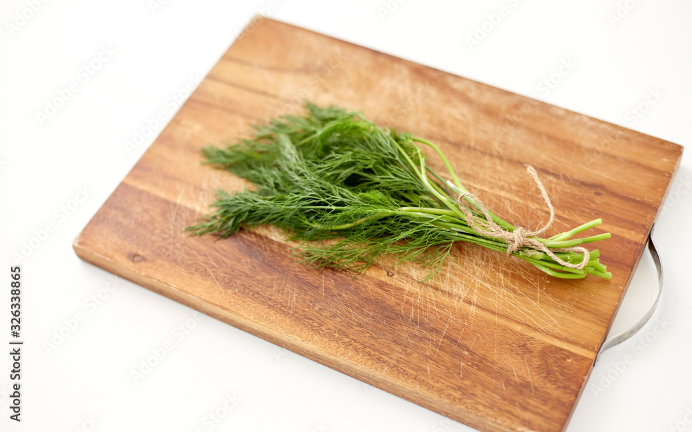 greens, culinary and ethnoscience concept - bunch of dill on wooden cutting board greens, culinary and ethnoscience concept - bunch of dill on wooden cutting board