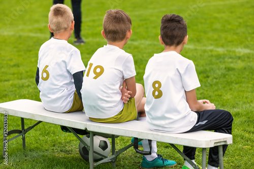 Boys in Sports Soccer Team Sitting on a Substitute Bench. Junior Level Sports Competition Outfoor Tournament. Back View on Football Bench photo