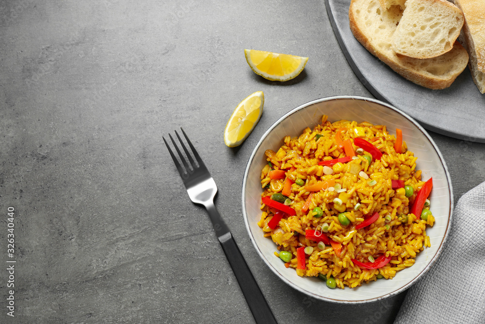 Delicious rice pilaf with vegetables on grey table, flat lay. Space for text Delicious rice pilaf with vegetables on grey table, flat lay. Space for text