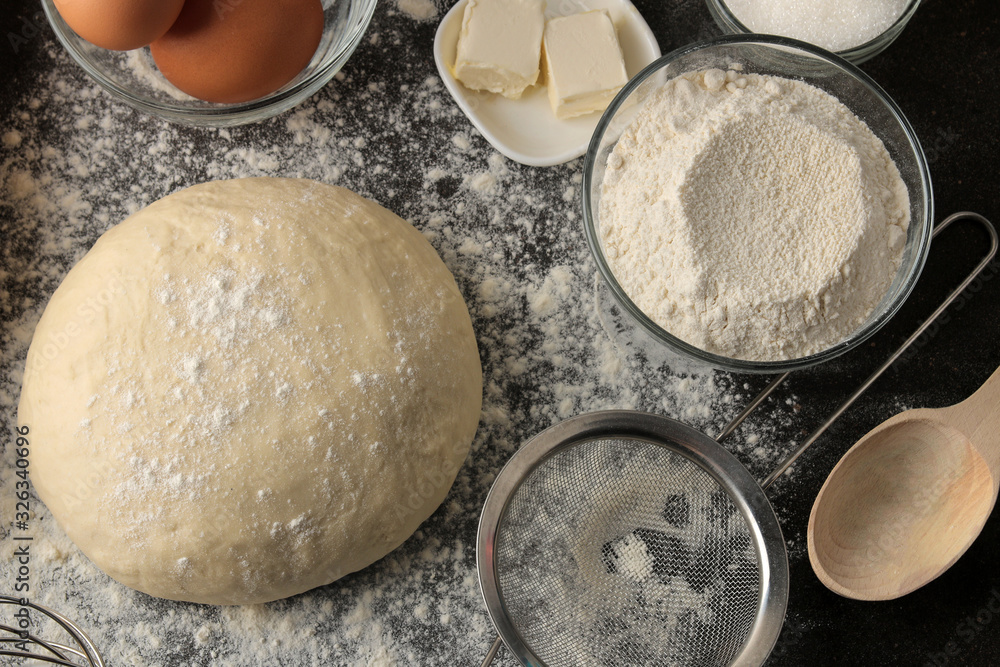 Dough for baking. making delicious cookies. Ingredients for the dough, eggs, flour, butter, sugar on a dark background Dough for baking. making delicious cookies. Ingredients for the dough, eggs, flour, butter, sugar on a dark background