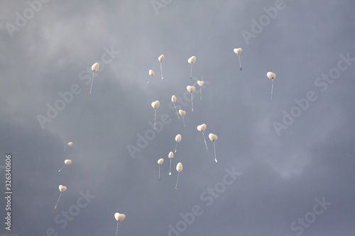 herzförmige ballons steigen mit guten wünschen in einen gewitterhimmel photo