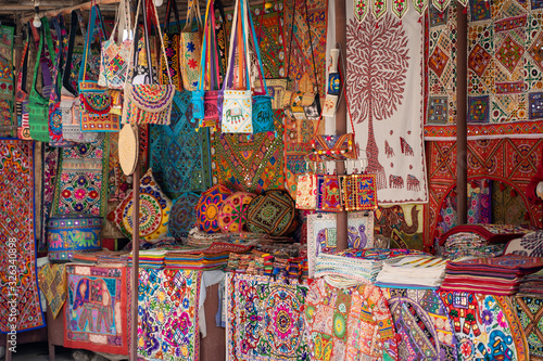 Bild auf Leinwand Vibrant, colorful market stall selling embroidered handicrafts such as pillow ca
