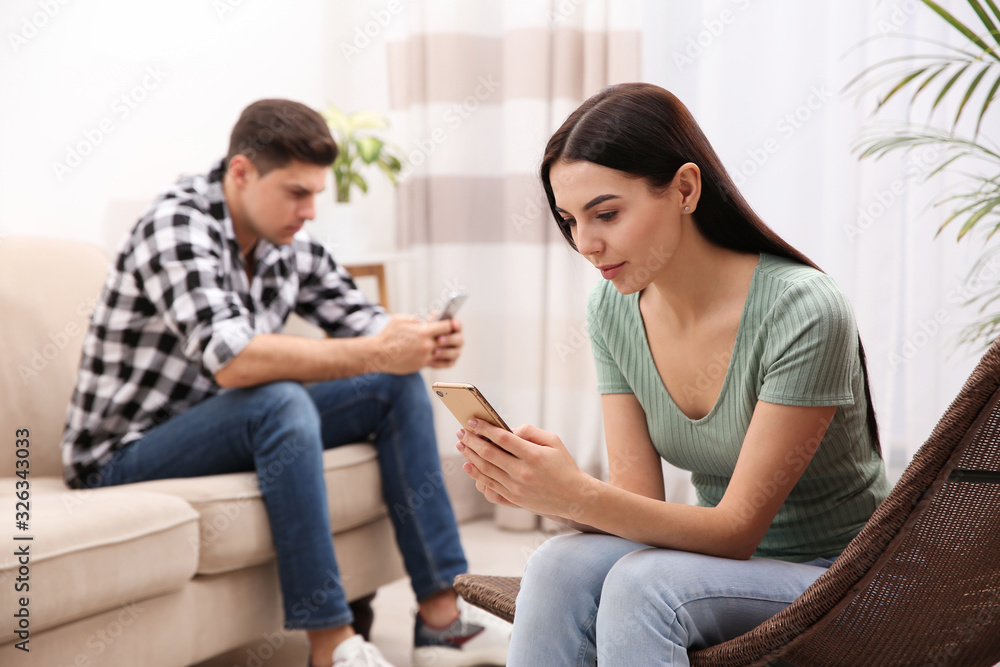 Couple addicted to smartphones ignoring each other at home. Relationship problems Couple addicted to smartphones ignoring each other at home. Relationship problems