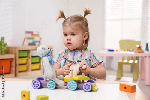Little girl playing with toys at table