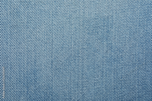 Texture of light blue jeans as background, closeup
