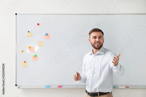 Foto Portrait of young teacher near whiteboard in classroom