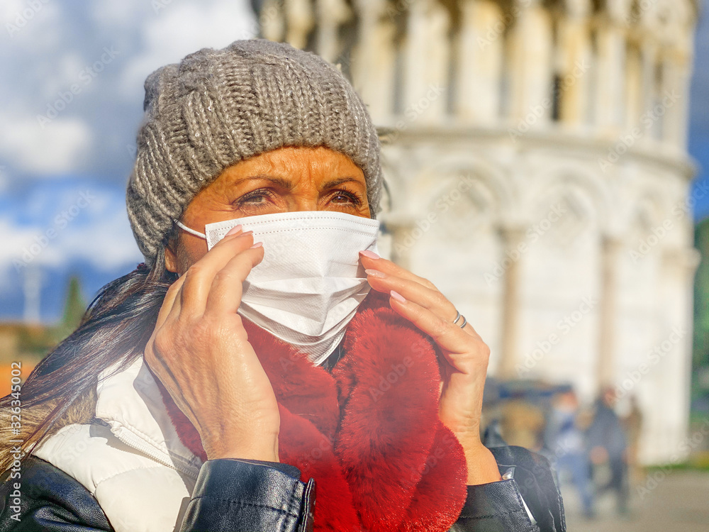 Plakat Coronavirus Covid-19 is spreading across Italy and Europe. Woman visiting Pisa wearing protective face mask to avoid contagion outbreak