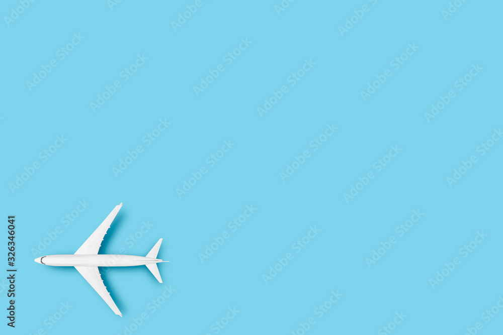 Fototapeta Samolot zabawka na niebieskim tle. Koncepcja podróży, bilety lotnicze, lot. Płaski układanie, widok z góry