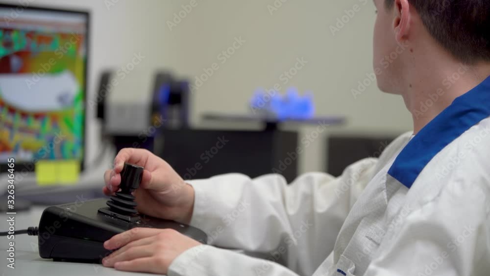 engineer scans high-quality plastic component with 3D scanner, rotating platform using joystick engineer scans high-quality plastic component with 3D scanner, rotating platform using joystick