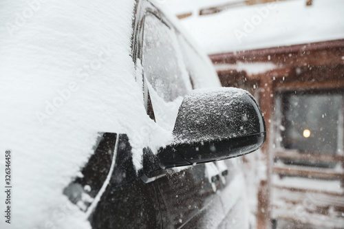 Modern car covered with snow outdoors on winter day, closeup