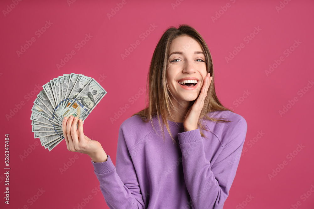 Happy young woman with cash money on pink background Happy young woman with cash money on pink background